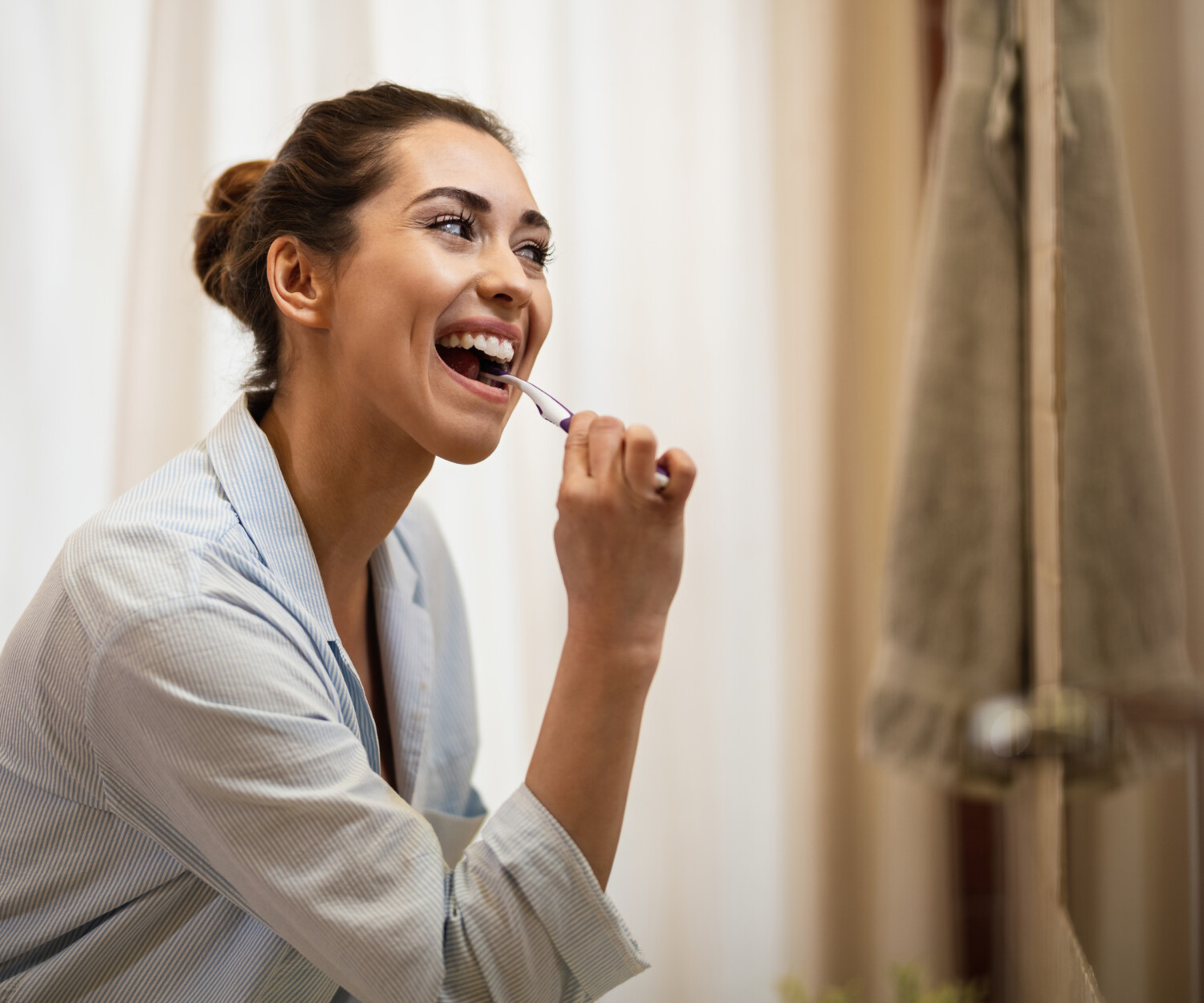 Woman practicing preventive dental care by brushing.