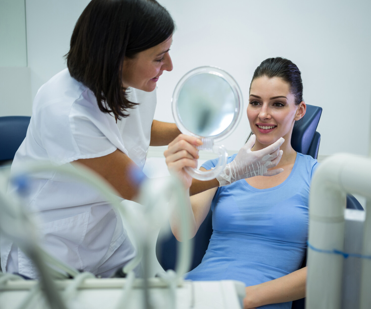 woman checking her smile after getting cosmetic dentistry done.