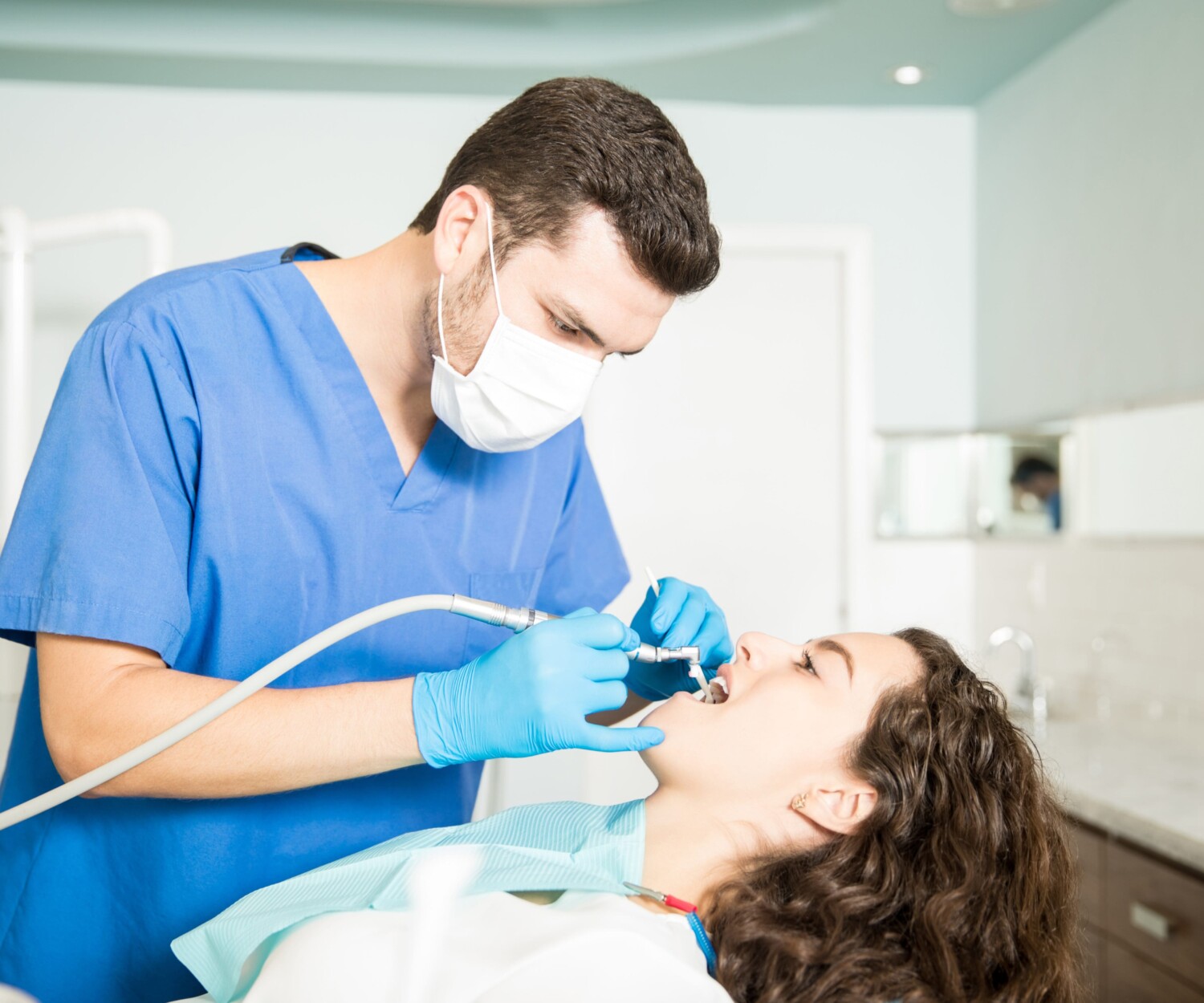 Young woman receiving dental treatment from dentist in clinic