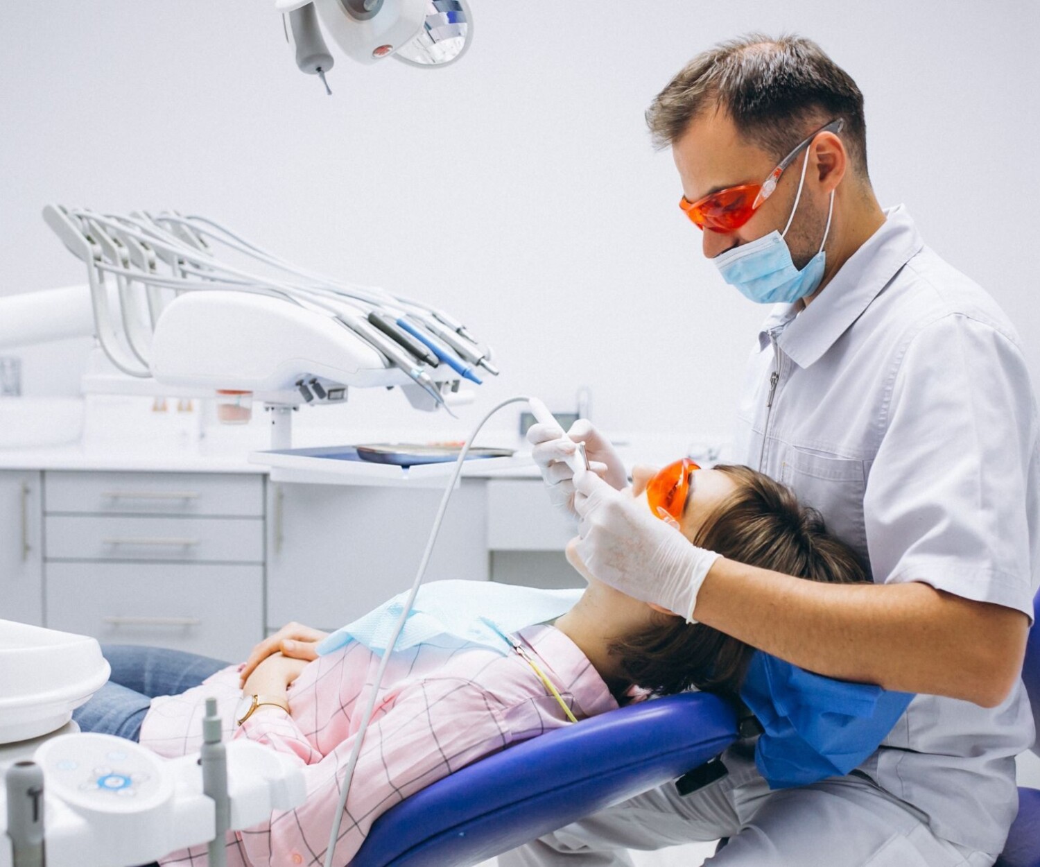 A dentist performing a procedure on his patient