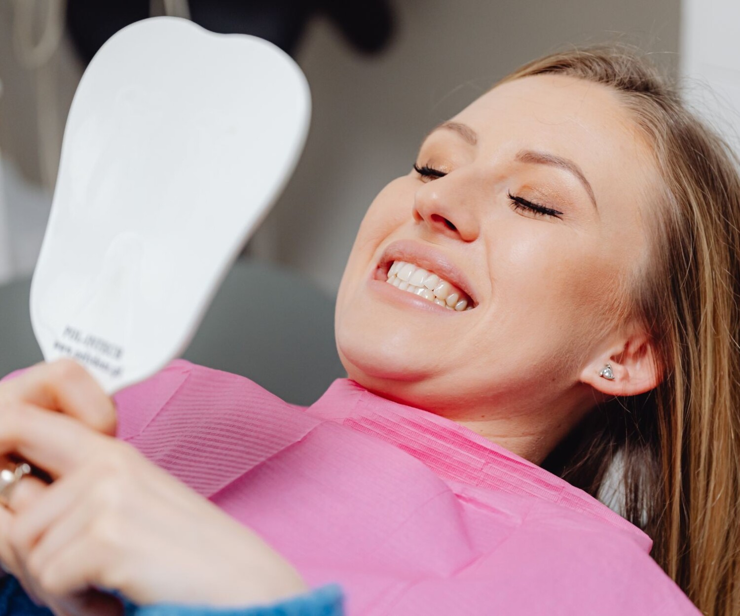 Woman checking her teeth at a cosmetic dental clinic
